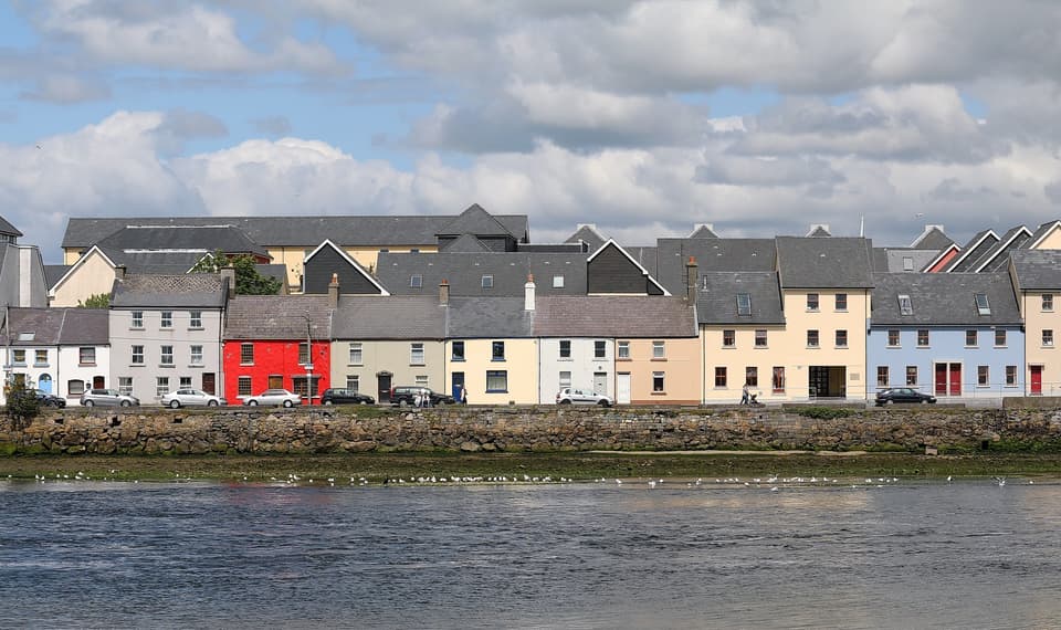 The row of colourful houses along the Long Walk in Galway, seen across the River Corrib.