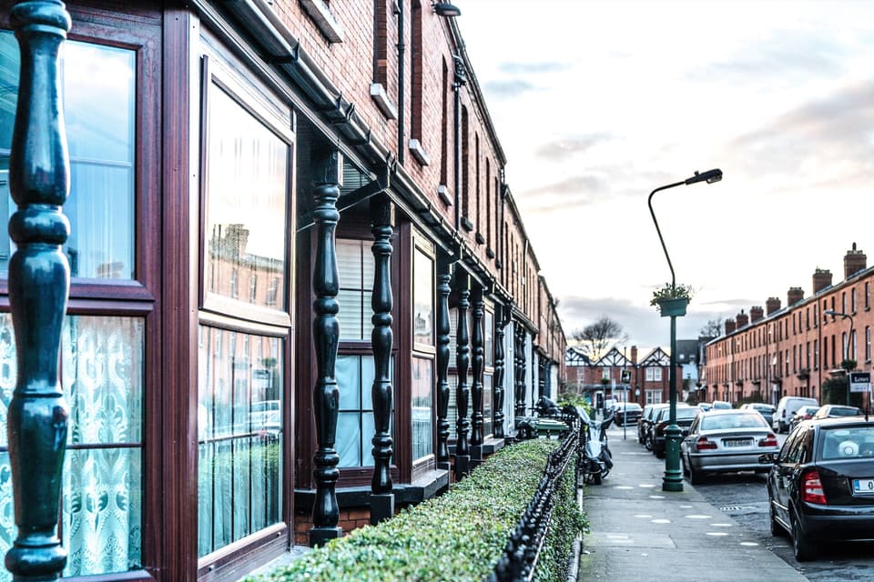 A row of red-brick terraced houses with front railings on Cabra Park, Phibsborough.